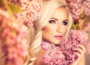 Blonde sexy Frau inmitten von rosa Blumen